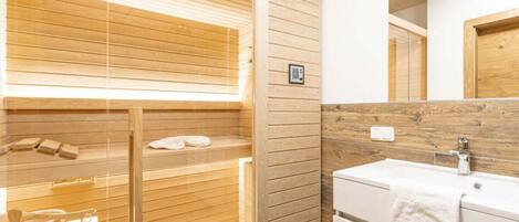 Ein modernes Badezimmer mit einer Holzauszeit, einem Waschbecken und einem Spiegel.