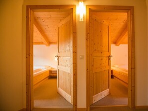 A wooden door leading to a bedroom with a single bed. - Cabin in Annaberg With Swimming Pool (Annaberg-Lungoetz)