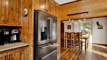 Una cocina con armarios de madera, un refrigerador de acero inoxidable y una cafetera.