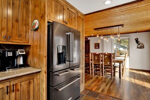 Una cocina con armarios de madera, un refrigerador de acero inoxidable y una cafetera.