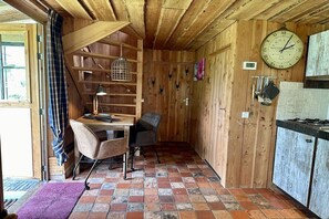 A rustic wooden interior with a wooden desk, chair, and a clock on the wall. - Holiday home in Limmen with swimming pool (Limmen)