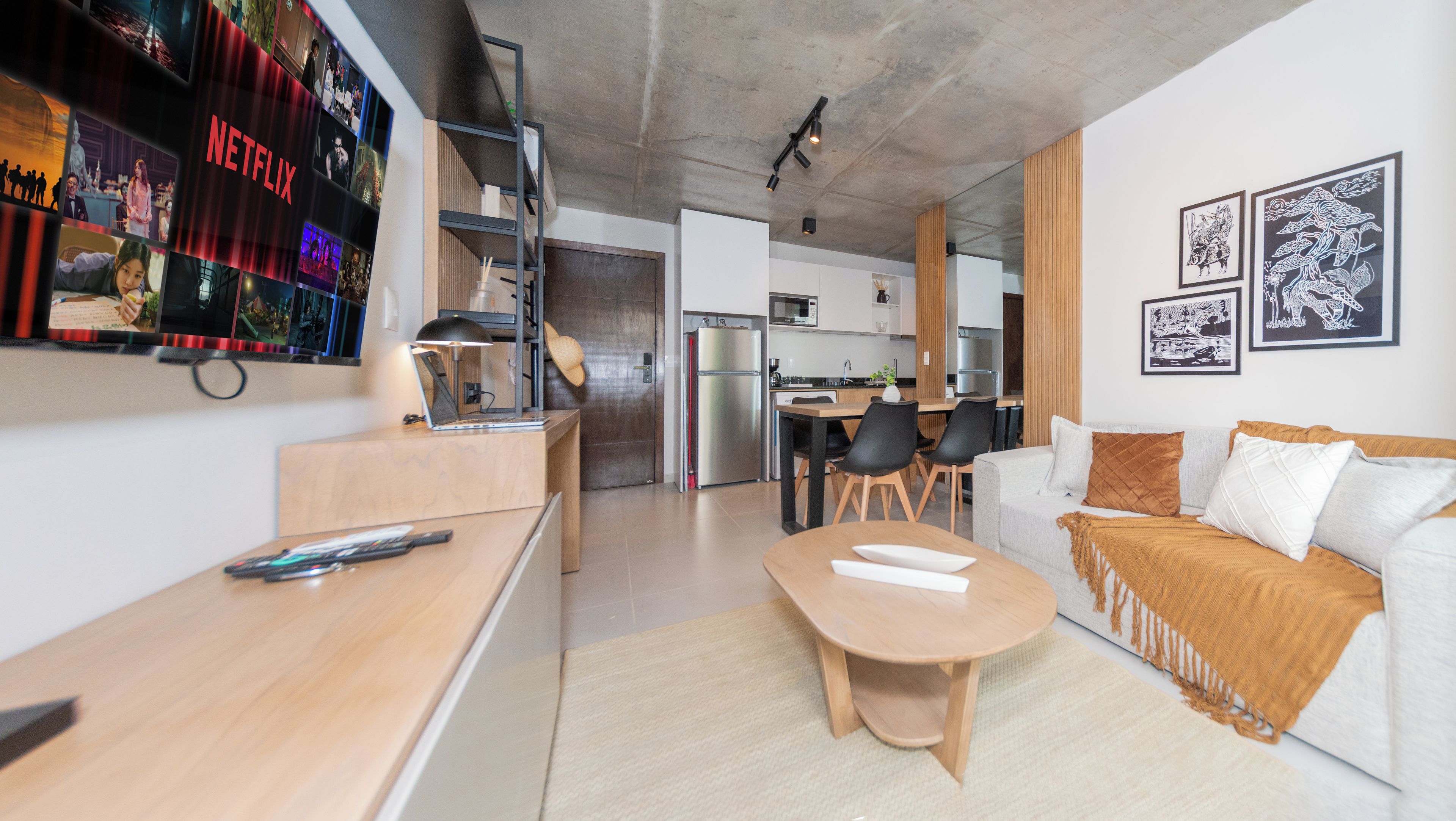 A modern living space with a kitchen, dining area, and a seating area with a sofa and a coffee table.