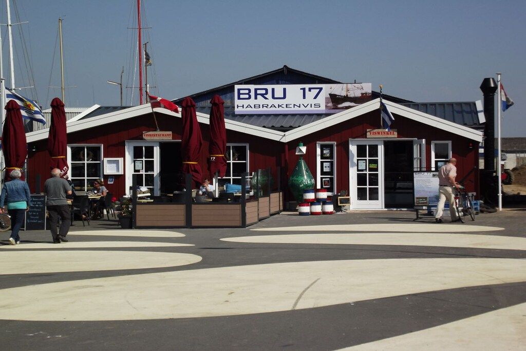 A red building with a sign reading 'BRU 17 HABRAKENVIS' and a restaurant sign.