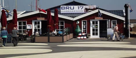A red building with a sign reading 'BRU 17 HABRAKENVIS' and a restaurant sign.