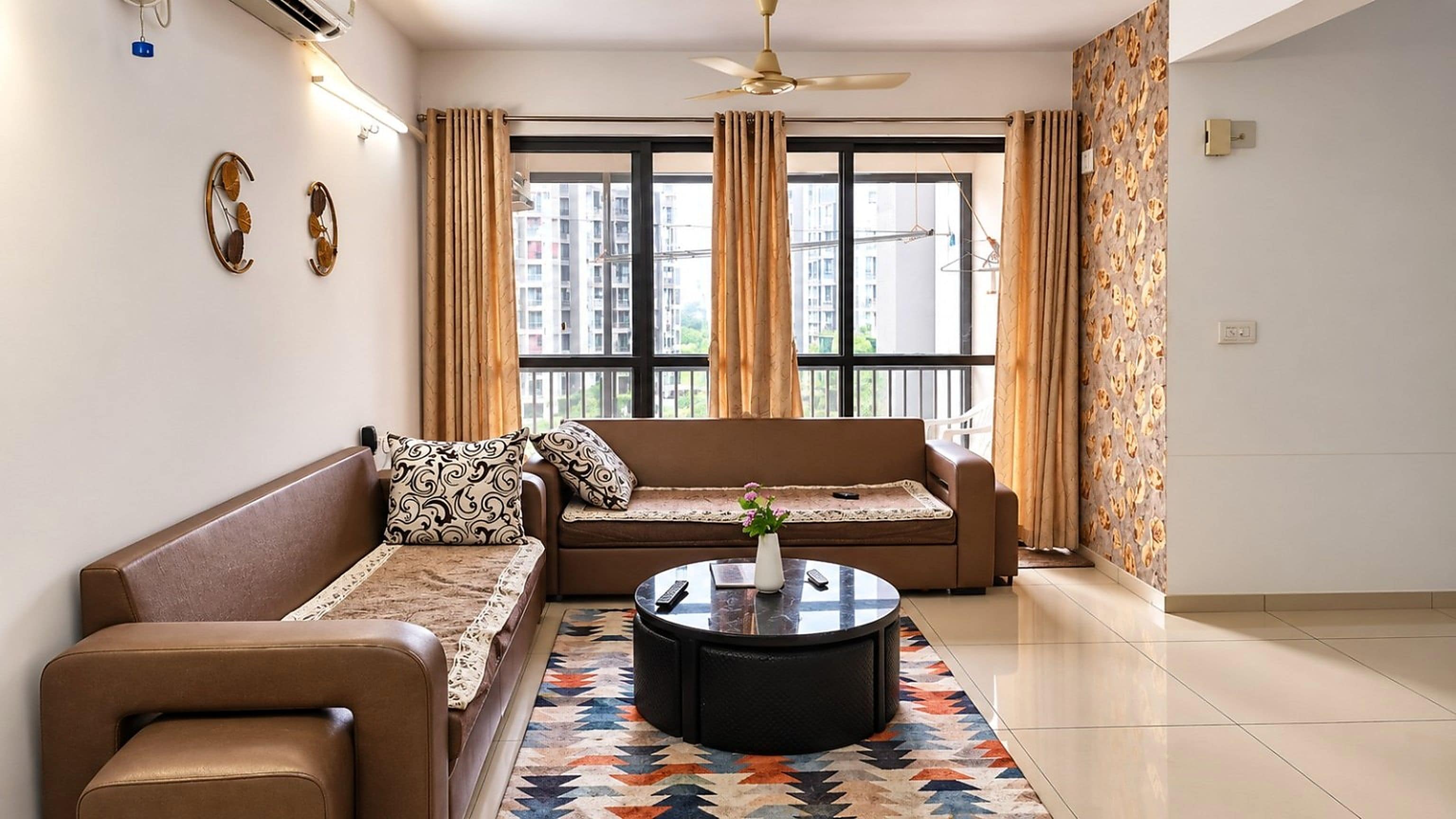 Una sala de estar con sofá, mesa de centro y alfombra estampada.