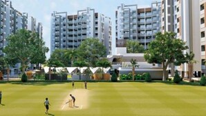 Un quartiere residenziale con palazzi alti, un campo da cricket e aree verdi.