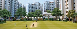 Ein Wohngebiet mit Hochhäusern, einem Cricket-Platz und Grünflächen.