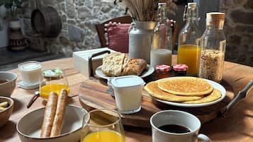 Une table de petit-déjeuner avec divers aliments et boissons.