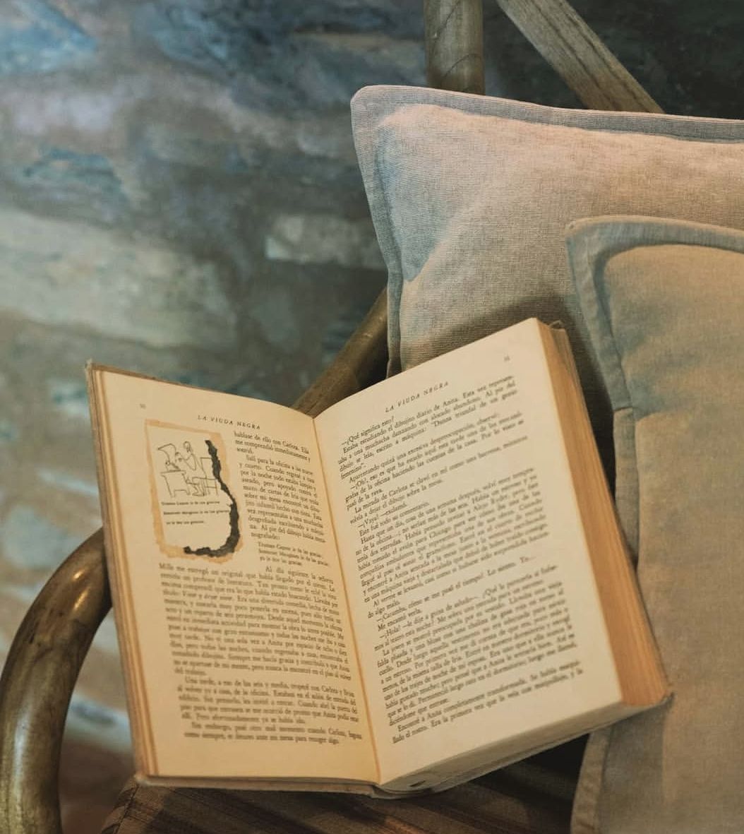 Un libro abierto sobre una silla con un cojín.