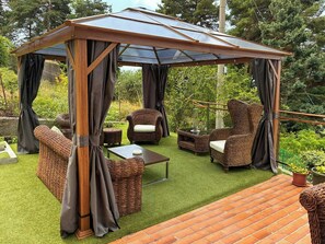 A covered outdoor seating area with wicker furniture and a glass roof. - Hillside villa with terraced garden near Bajardo (Bajardo)