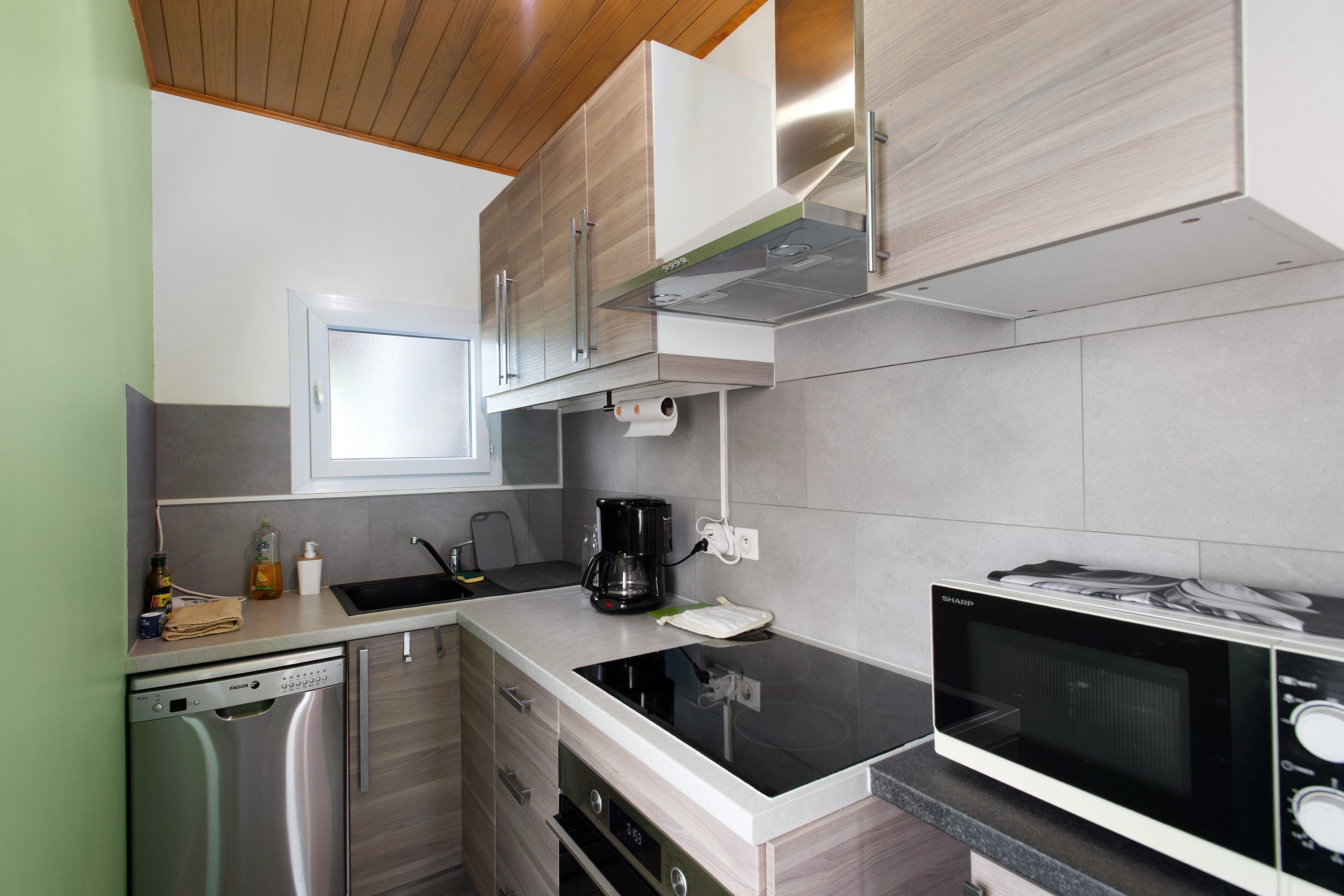 Una cucina moderna con lavastoviglie, macchina del caffè e forno a microonde.