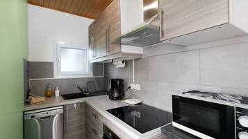Una cucina moderna con lavastoviglie, macchina del caffè e forno a microonde.