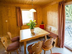 A wooden interior with a table and chairs, a potted plant, and a bench. - Cabin in Annaberg With Swimming Pool (Annaberg-Lungoetz)
