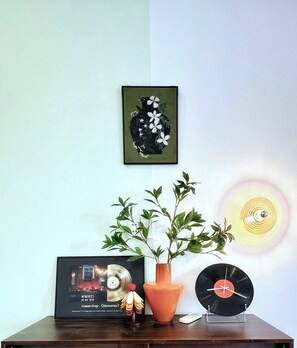 Ett bord med ett inramat CD-omslag, en krukväxt och en vinylskiva.