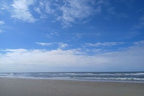 Ein Strand mit klarem Himmel und Wellen.