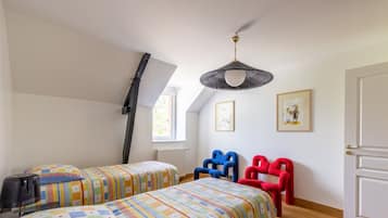 Un dormitorio con dos camas, una ventana, un radiador y una puerta.