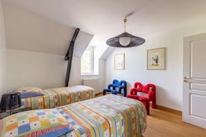 Un dormitorio con dos camas, una ventana, un radiador y una puerta.