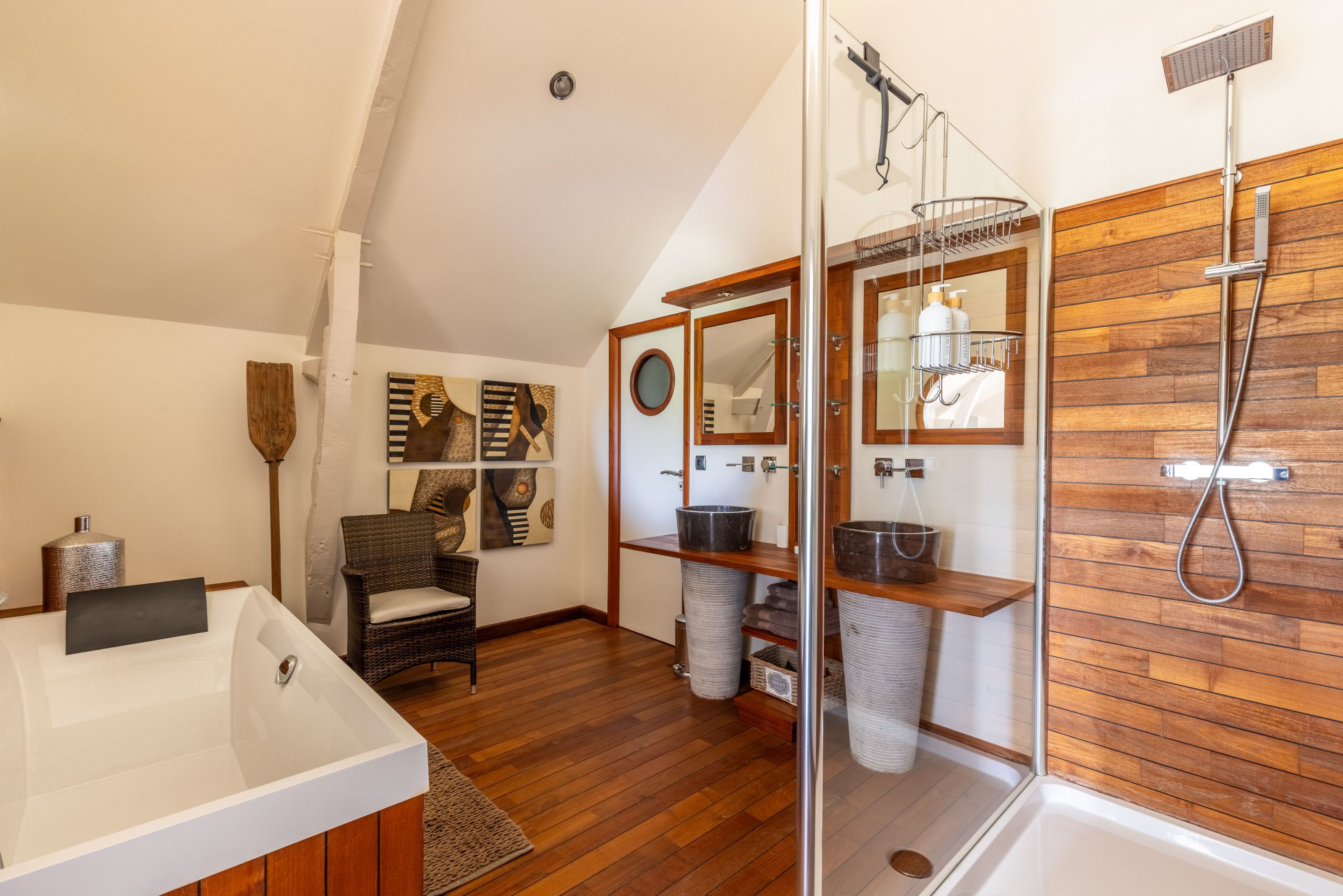 Une salle de bain moderne avec une baignoire sur pieds, une douche à parois de verre et un lambris en bois sur les murs.
