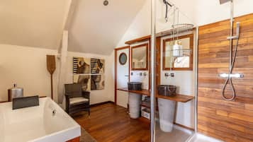 Une salle de bain moderne avec une baignoire sur pieds, une douche à parois de verre et un lambris en bois sur les murs.