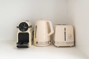 Three kitchen appliances: a coffee maker, a kettle, and a toaster. - One-Bedroom Apartment (Paris)