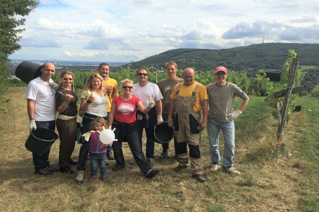 A group of people standing outdoors with a hilly landscape in the background.
