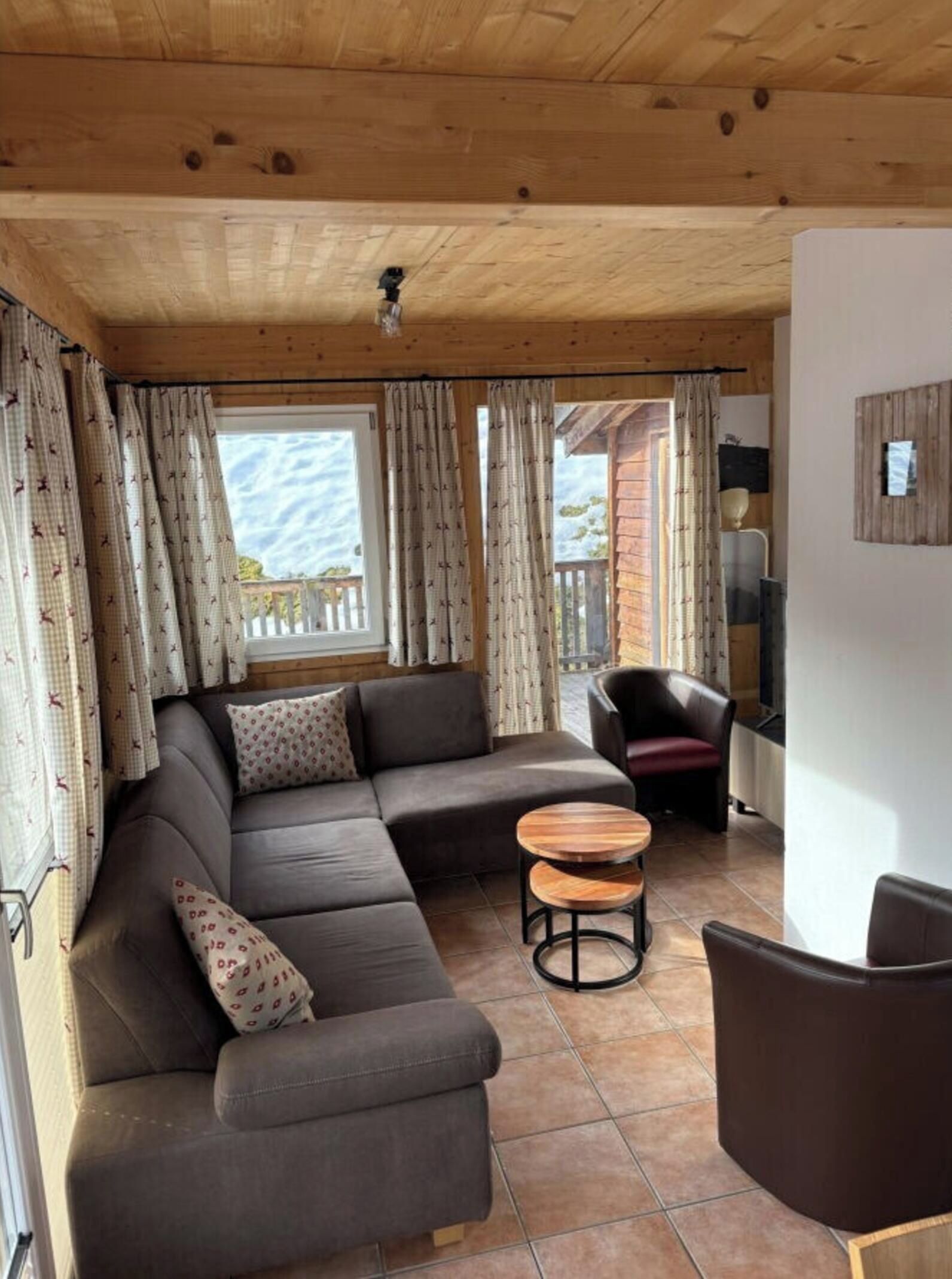 A cozy living room with a sectional sofa, a round coffee table, and a chair.