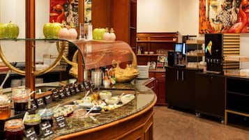 Ein Frühstücksbereich eines Hotels mit Buffet, einschließlich verschiedener Speisen und Beilagen.