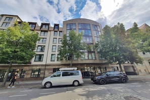 A multi-story building with a modern architectural design, featuring a curved facade and large windows. - Sunday Hotel & Suites Leipzig - Suite Plus (Leipzig)