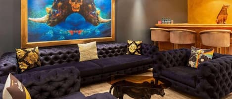 Un soggiorno lussuoso con un grande quadro astratto, divani confortevoli e una statuetta decorativa a forma di cane.