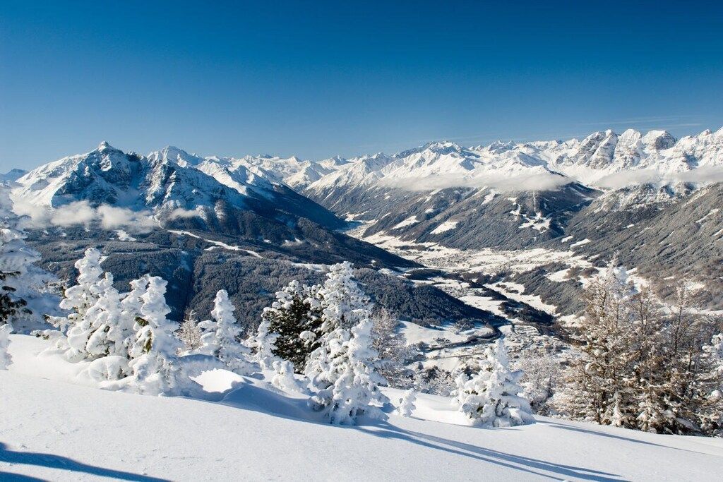 Eine verschneite Berglandschaft mit blauem Himmel.