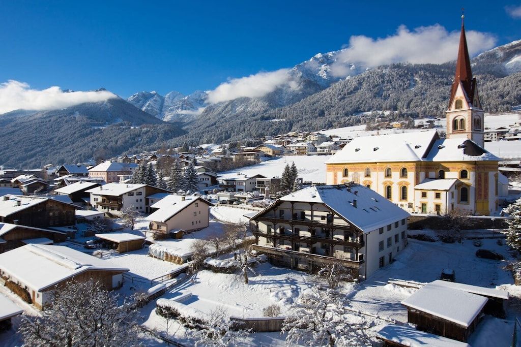A snow-covered village with a prominent church and traditional buildings.