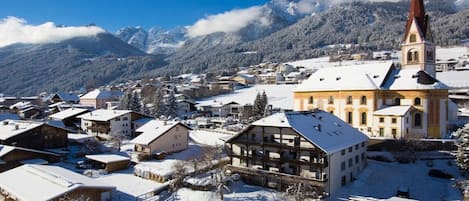 A snow-covered village with a prominent church and traditional buildings.