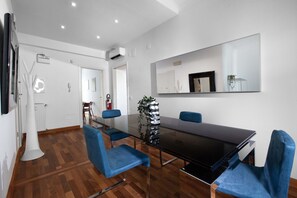 A conference room with a long table, blue chairs, a large mirror, and a potted plant. - Estate4home - Aranci 33 Guest House (Sorrento)