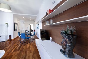 A modern interior with a wooden floor, white furniture, and a decorative plant. - Estate4home - Aranci 33 Guest House (Sorrento)