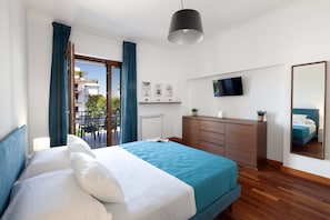 A hotel room with a bed, a dresser, a TV, and a balcony. - Aranci33 (Sorrento)