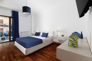 A modern bedroom with a bed, bedside tables, a lamp, and a decorative vase. - Aranci33 (Sorrento)