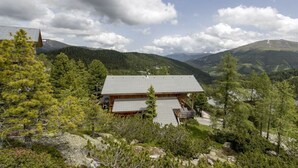 A lodge with a large wooden structure, surrounded by dense forest and mountains in the background. - Cabin in Turrach with sauna and balcony (Turrach)