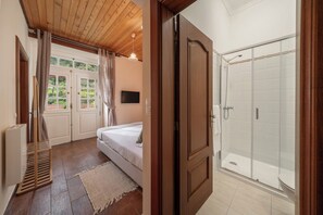 A bedroom with a bed, a wooden ladder, a TV, and a window with curtains. - Vrbo Property (São Jorge)