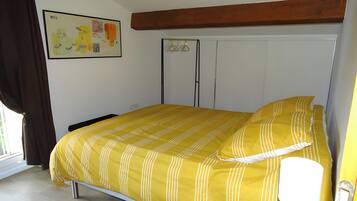 Quarto com cama, guarda-roupa e uma pintura na parede.