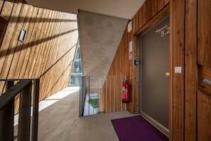 A wooden interior with a concrete ceiling, a fire extinguisher, and a door with a number. - Apartment in Rohrmoos-Untertal with balcony (Rohrmoos-Untertal)