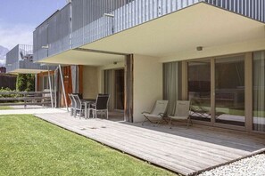 A modern outdoor deck with a dining area, seating, and a view of the mountains. - Apartment in Rohrmoos-Untertal with sauna (Rohrmoos-Untertal)