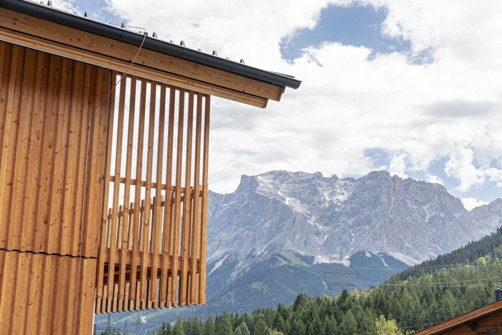 A wooden building with a slatted facade and a mountain view.