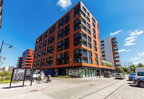 Un edificio de varios pisos con un diseño arquitectónico moderno, que combina balcones y ventanas.