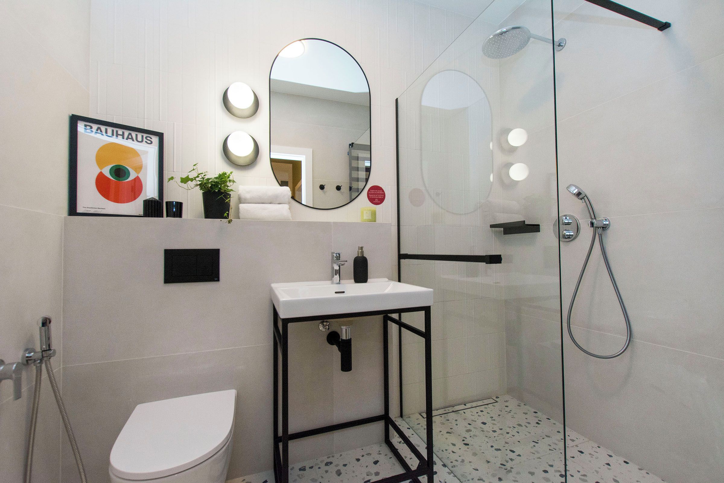 Une salle de bain moderne équipée de toilettes, d’un lavabo et d’une douche.
