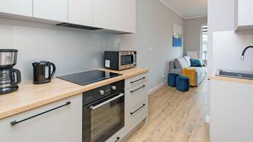A modern kitchen with a microwave, coffee maker, and oven.