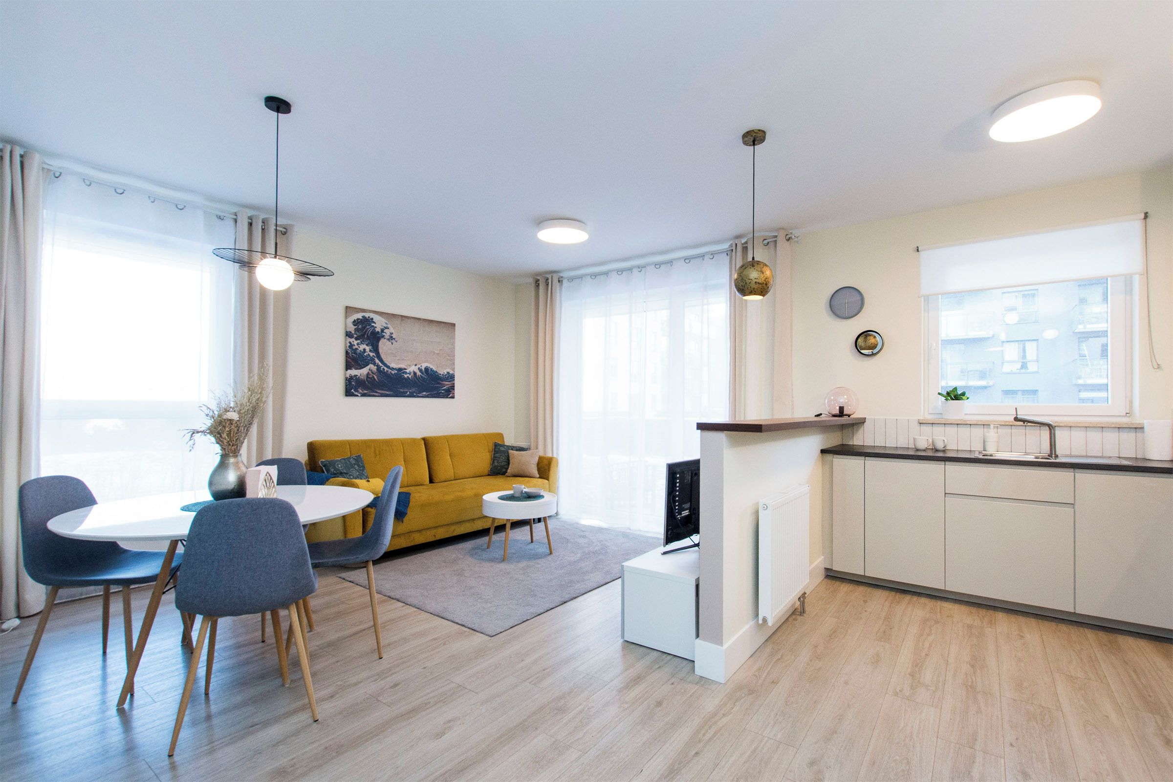Eine moderne Wohnung mit Essbereich, Sofa, Küche und Blick auf die Stadt.