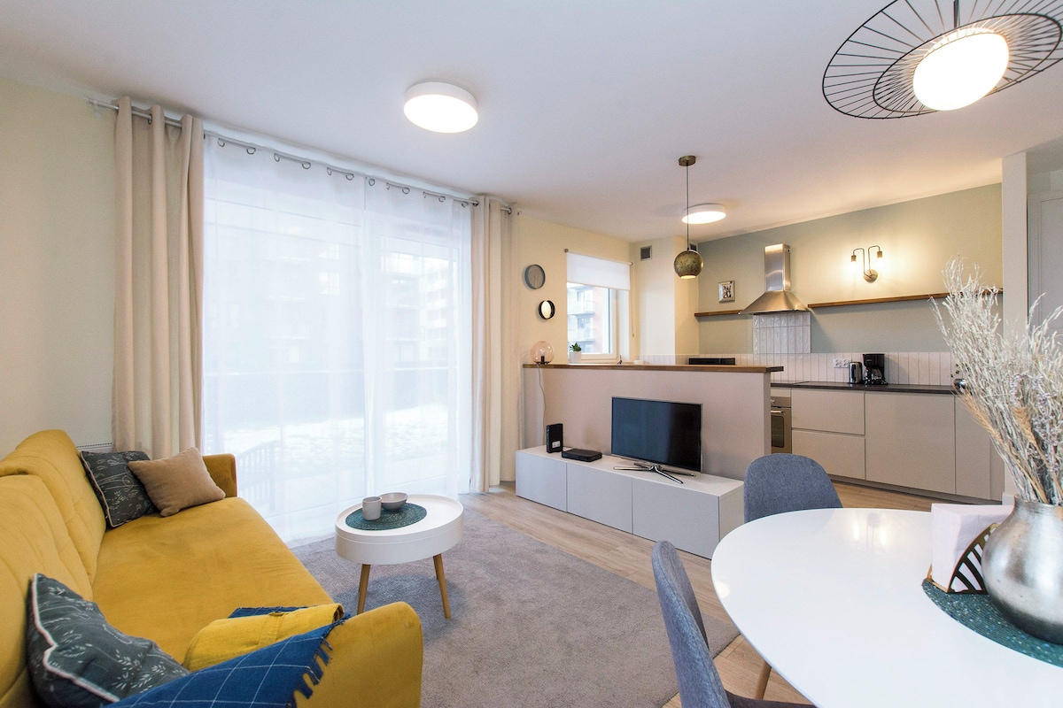 Ein modernes Wohnzimmer mit einer Couch, einem Couchtisch und einem Essbereich mit Tisch und Stühlen.