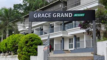 A multi-story building with a sign reading 'GRACE GRAND RESORT'.