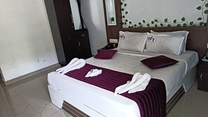 Ein Hotelzimmer mit Bett, Nachttisch, Telefon und einem an der Wand befestigten Spiegel.