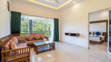 A modern living room with a sofa, coffee table, and a bed with a headboard.
